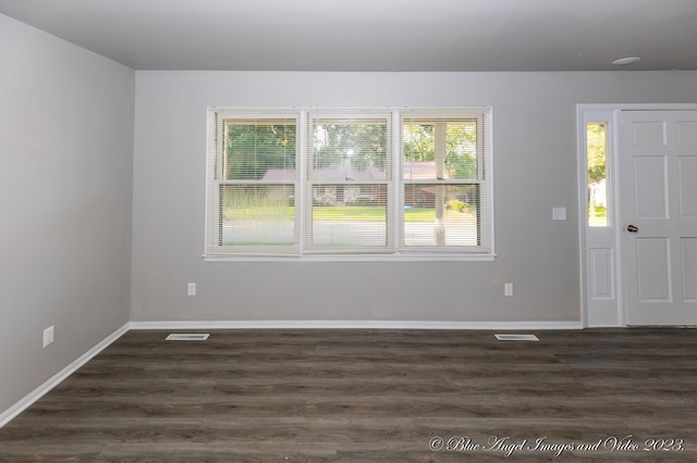 foyer featuring dark wood-type flooring, visible vents, and baseboards
