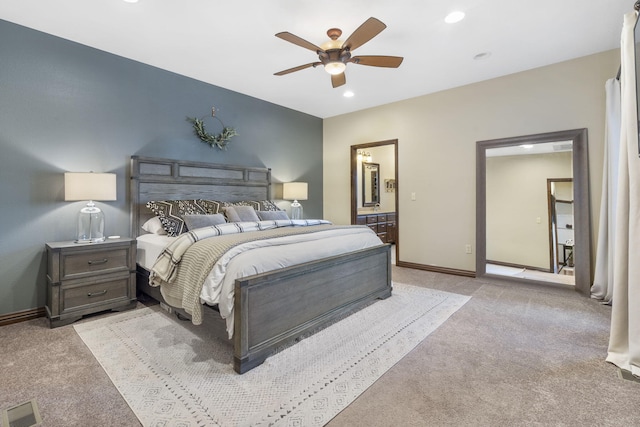 bedroom featuring ceiling fan, ensuite bathroom, and light carpet