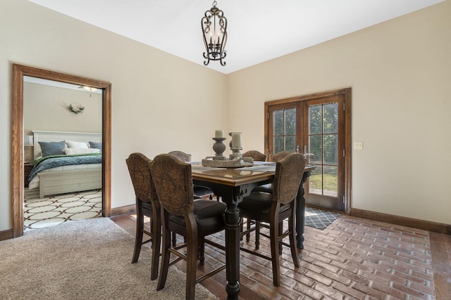 dining room featuring french doors and a chandelier