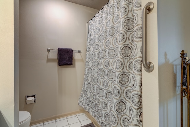 bathroom featuring tile patterned flooring, walk in shower, and toilet