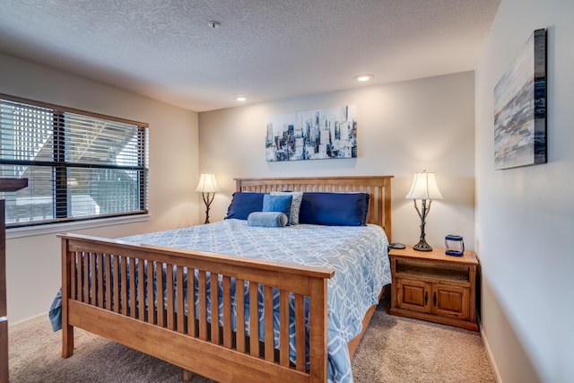 bedroom featuring light carpet and a textured ceiling