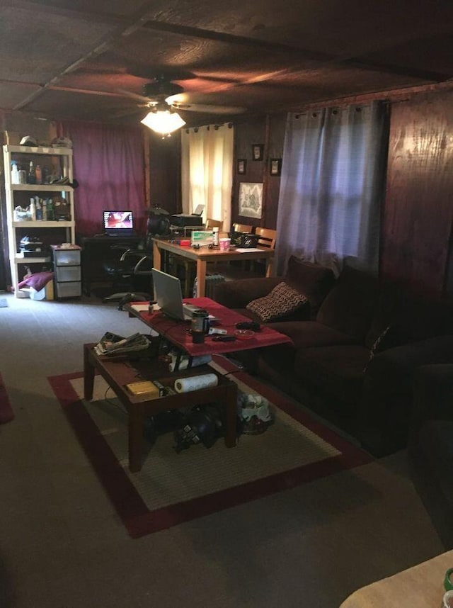 living room with ceiling fan and wooden walls