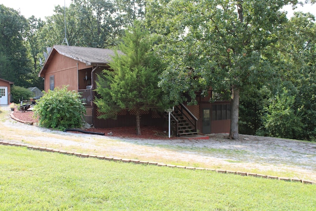 view of front of house featuring a front lawn and a wooden deck