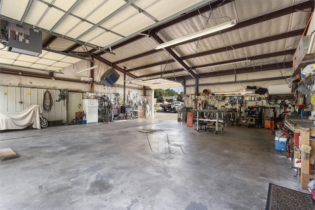 garage featuring a workshop area and white fridge