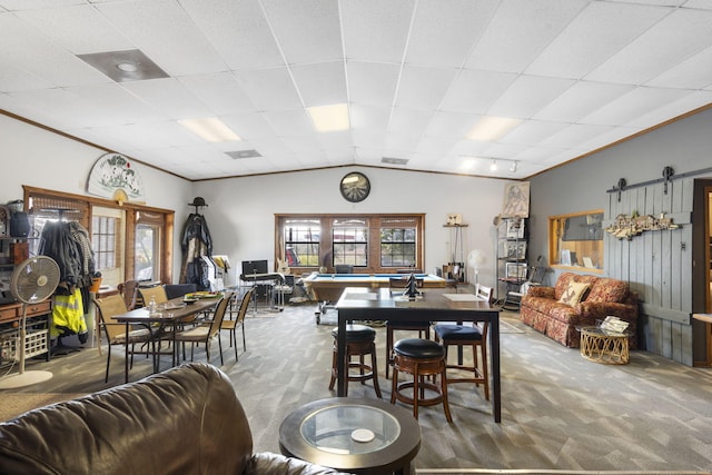 carpeted dining space with a barn door, pool table, and a paneled ceiling