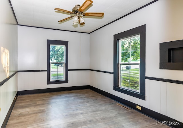 spare room featuring light wood-style flooring, visible vents, and a wealth of natural light