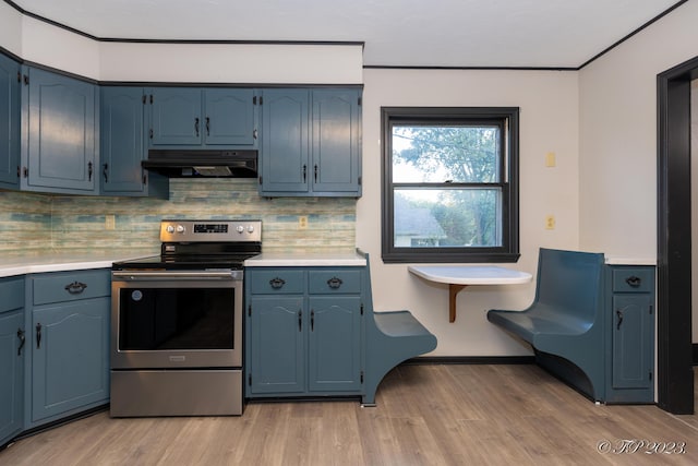 kitchen with light countertops, stainless steel range with electric cooktop, light wood-type flooring, and under cabinet range hood