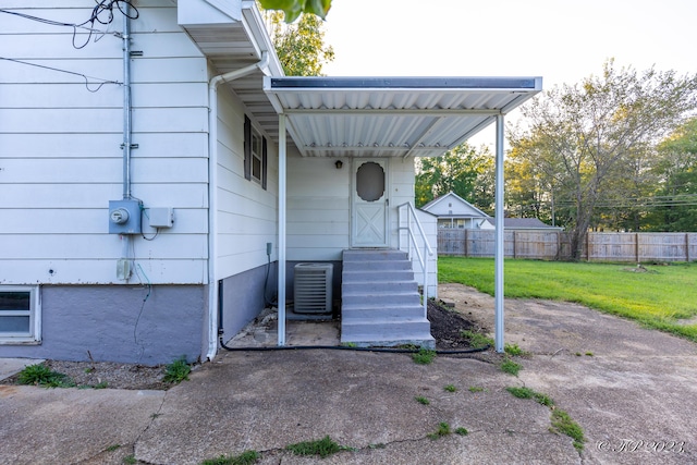 exterior space featuring fence, a yard, and central AC
