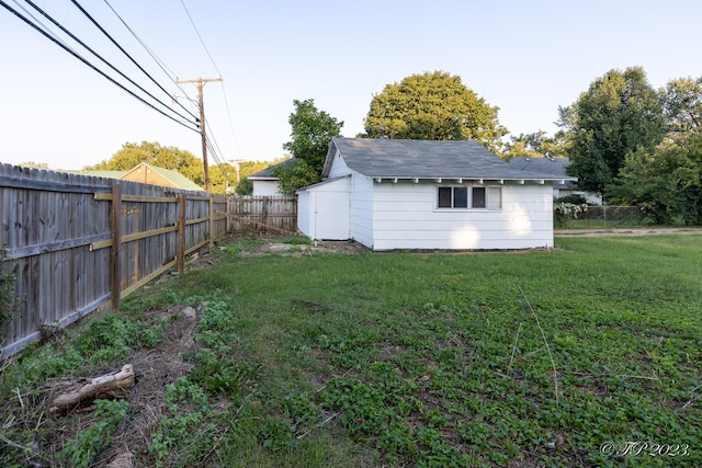view of yard with a storage unit, an outbuilding, and a fenced backyard