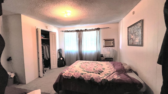 bedroom with an AC wall unit, light carpet, a closet, and a textured ceiling