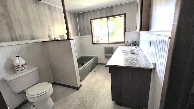 bathroom with vanity, toilet, and a washtub