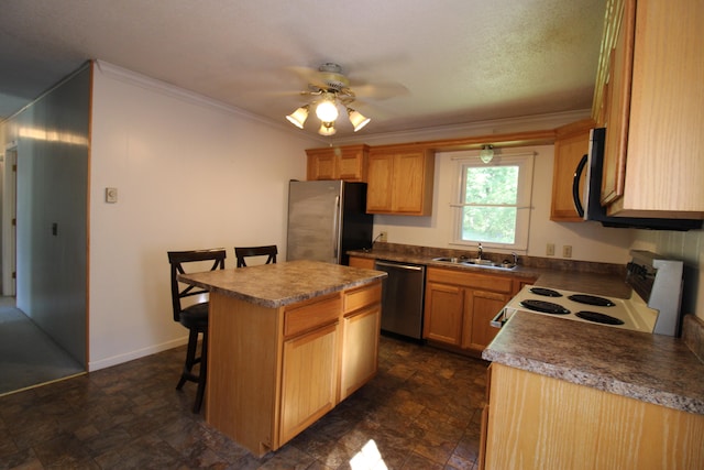 kitchen with ceiling fan, sink, a kitchen island, stainless steel appliances, and a breakfast bar