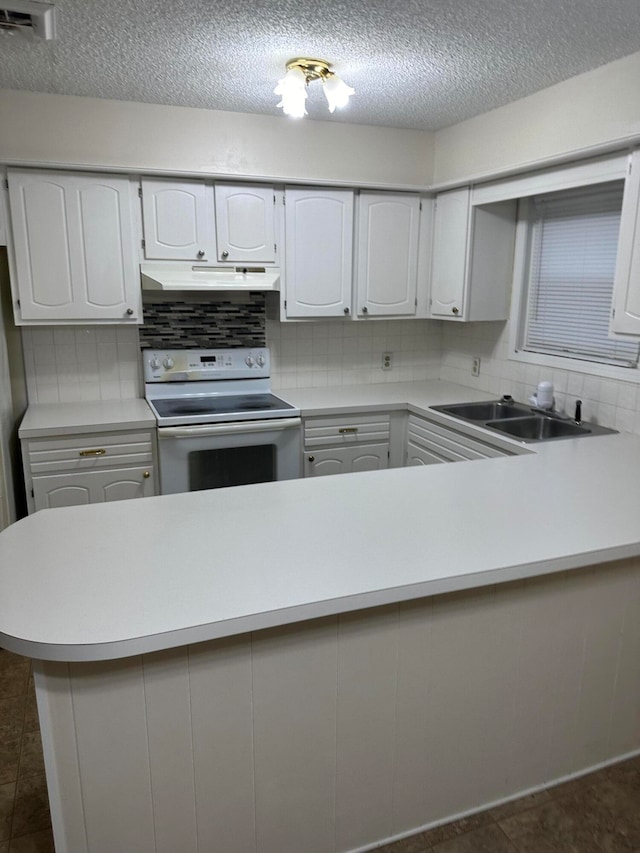 kitchen featuring dark tile patterned floors, tasteful backsplash, sink, white cabinetry, and electric range