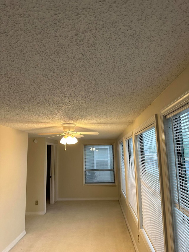 carpeted empty room featuring ceiling fan and a textured ceiling