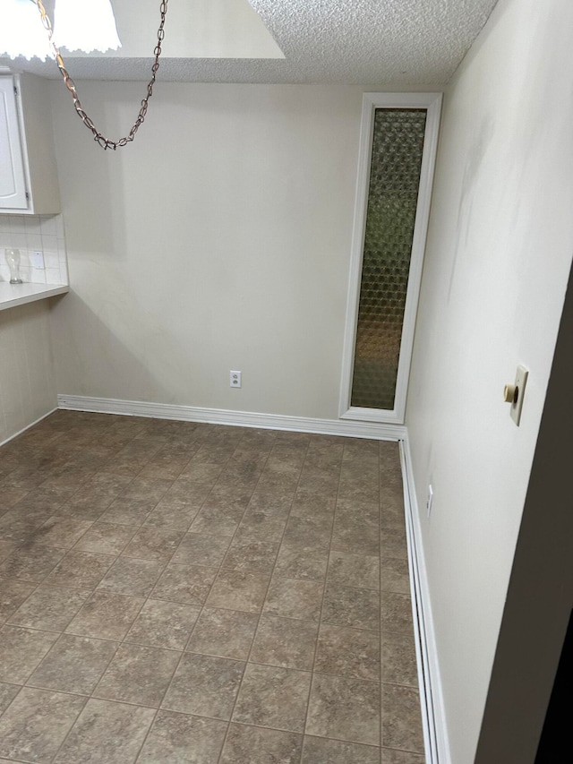 unfurnished room featuring a textured ceiling