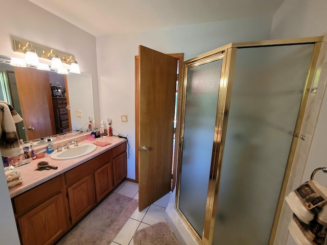 bathroom with tile patterned flooring, a shower with door, and vanity