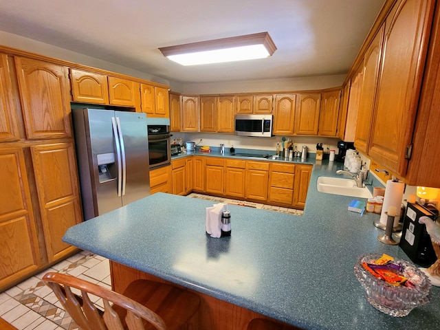 1201 Railey Creek Rd, Reeds Spring, MO 65737 - kitchen featuring brown cabinets, stainless steel appliances, a breakfast bar, a sink, and a peninsula