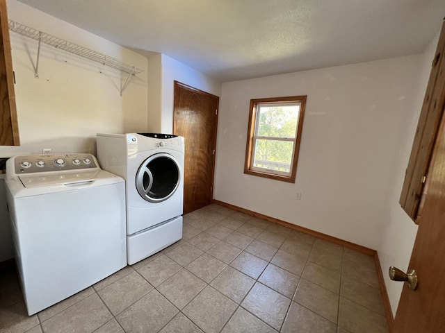 laundry area featuring light tile patterned flooring, baseboards, washer and dryer, and laundry area
