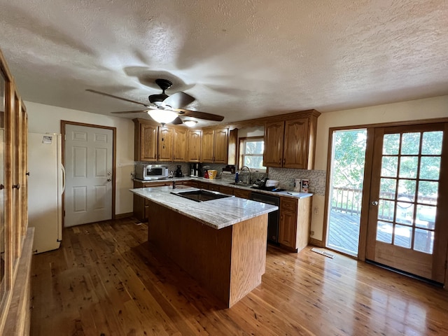 kitchen featuring black appliances, tasteful backsplash, wood finished floors, and a textured ceiling