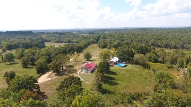 drone / aerial view featuring a rural view and a view of trees