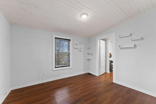 empty room featuring dark hardwood / wood-style flooring and wooden ceiling