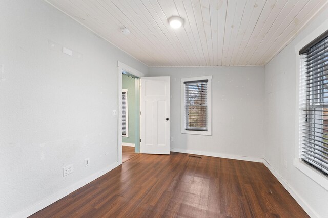 spare room featuring a healthy amount of sunlight, wood ceiling, and dark hardwood / wood-style floors