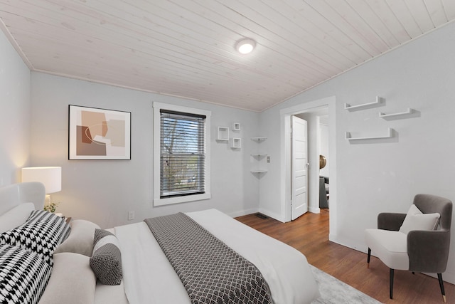 bedroom with vaulted ceiling, hardwood / wood-style floors, and wooden ceiling