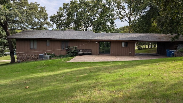 rear view of property with central air condition unit, a lawn, and a patio area