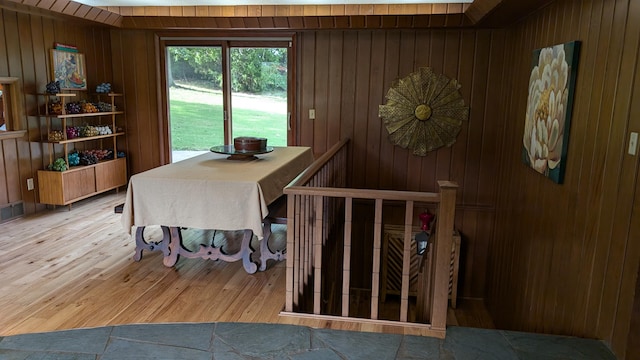 dining area featuring hardwood / wood-style flooring and wood walls