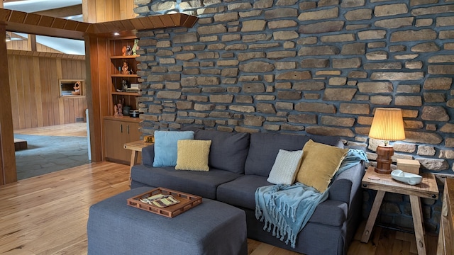 unfurnished living room with hardwood / wood-style flooring and wooden walls