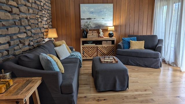 living room with light hardwood / wood-style flooring and wooden walls