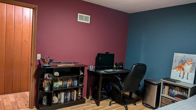 office with hardwood / wood-style flooring and a textured ceiling