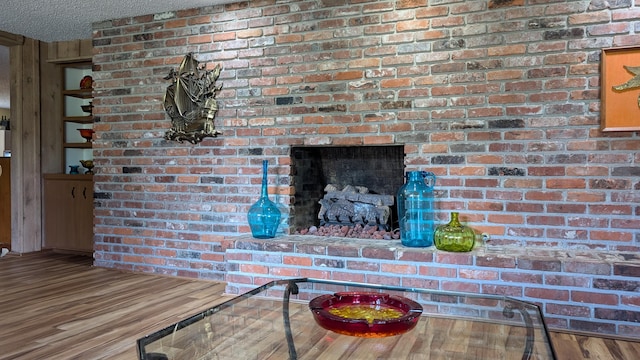 interior details featuring a textured ceiling, a fireplace, and hardwood / wood-style flooring