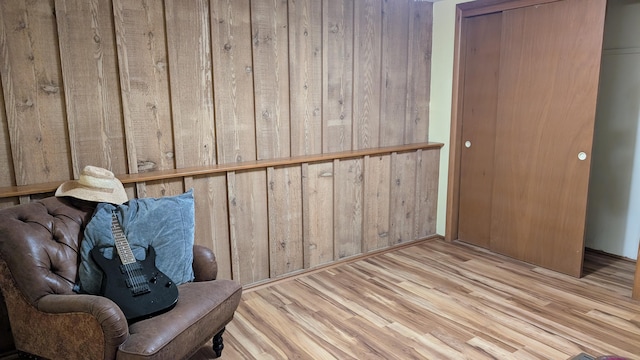 unfurnished room featuring wooden walls and light hardwood / wood-style flooring