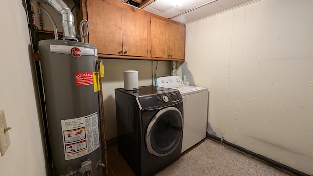 laundry area with gas water heater, washing machine and clothes dryer, and cabinets