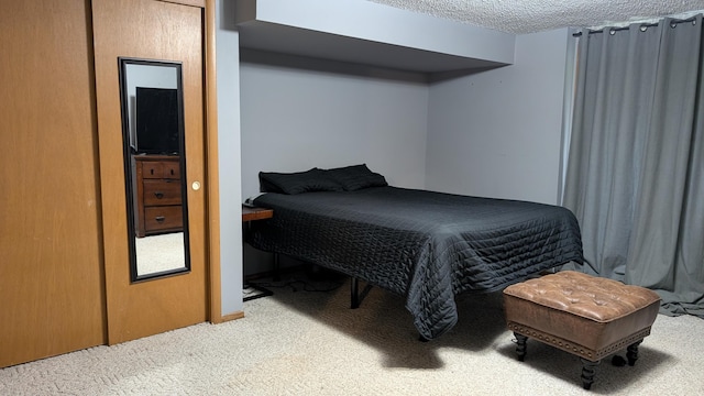 bedroom featuring a textured ceiling and light colored carpet