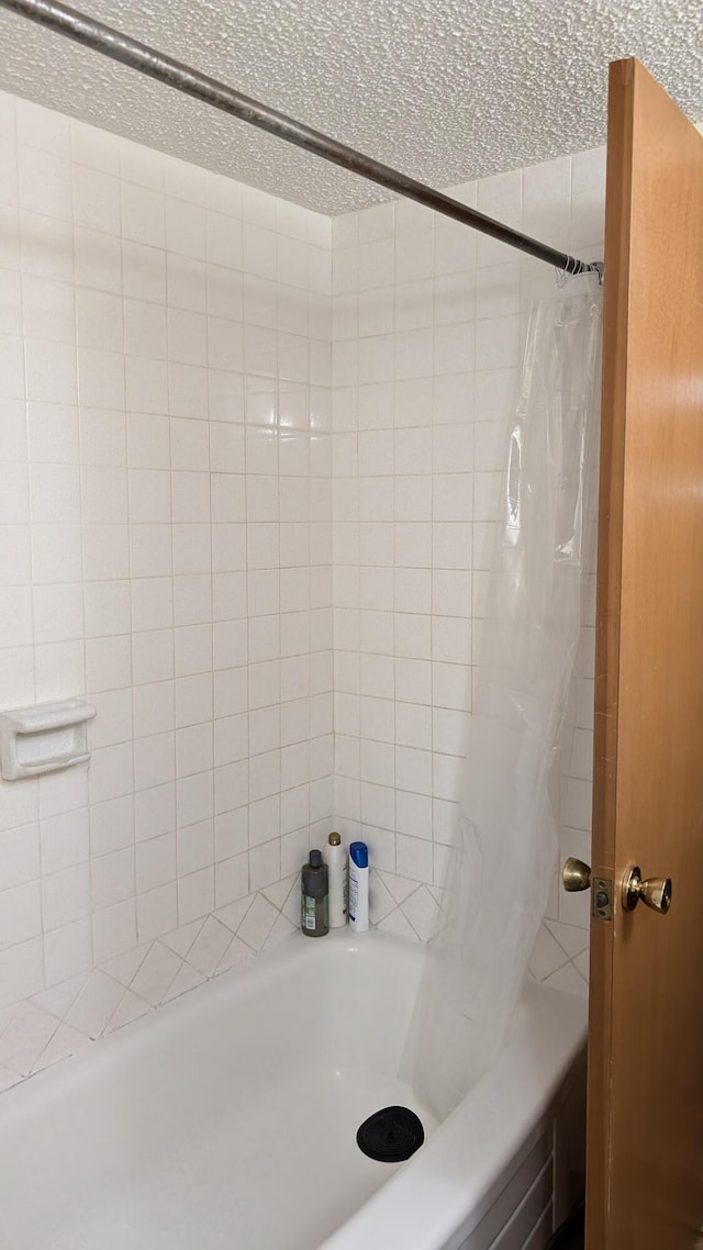 bathroom with shower / bath combo with shower curtain