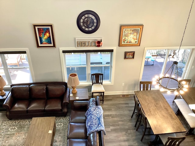 living room featuring a notable chandelier, hardwood / wood-style flooring, and a healthy amount of sunlight