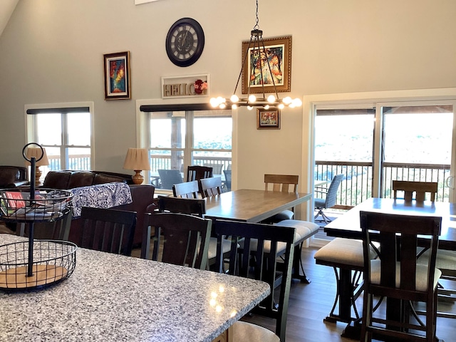 dining room featuring a notable chandelier, dark hardwood / wood-style flooring, and high vaulted ceiling