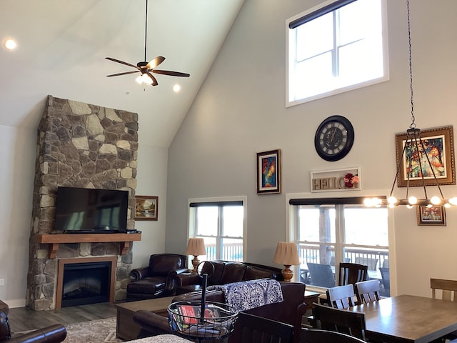 living room featuring hardwood / wood-style flooring, high vaulted ceiling, ceiling fan, and a fireplace