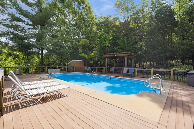 view of pool featuring a pergola, a storage unit, and a deck