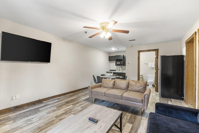 living room featuring ceiling fan and hardwood / wood-style floors