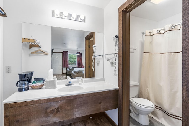 bathroom with vanity, hardwood / wood-style floors, toilet, and curtained shower