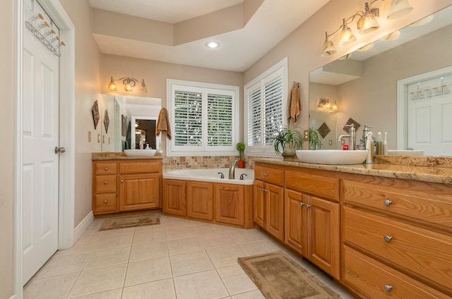 bathroom with tile patterned floors, a bath, and vanity