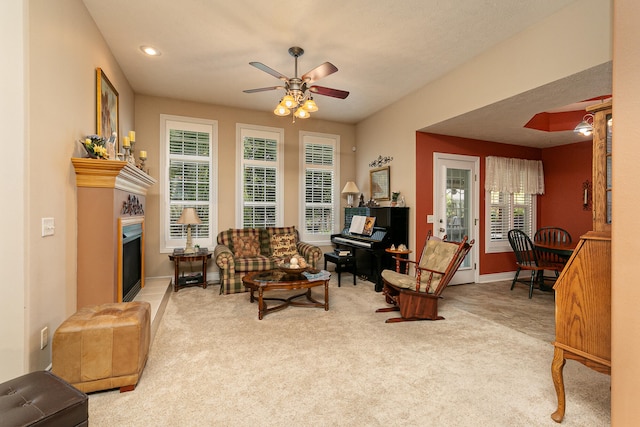 living area with ceiling fan and carpet floors