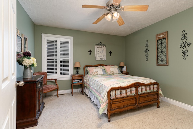 bedroom featuring ceiling fan, light colored carpet, and a textured ceiling