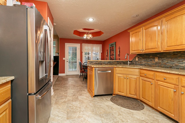 kitchen featuring sink, appliances with stainless steel finishes, tasteful backsplash, light stone counters, and a textured ceiling