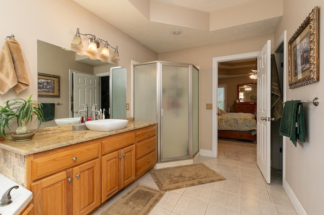 bathroom with a shower with door, vanity, tile patterned floors, and a textured ceiling