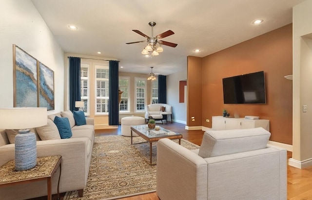 living room with wood-type flooring and ceiling fan