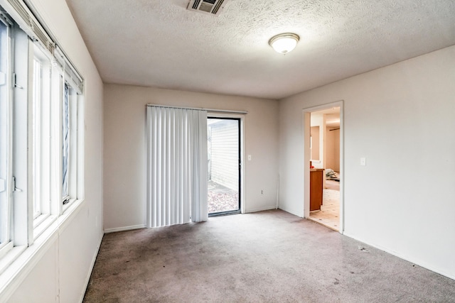 unfurnished room with carpet floors and a textured ceiling